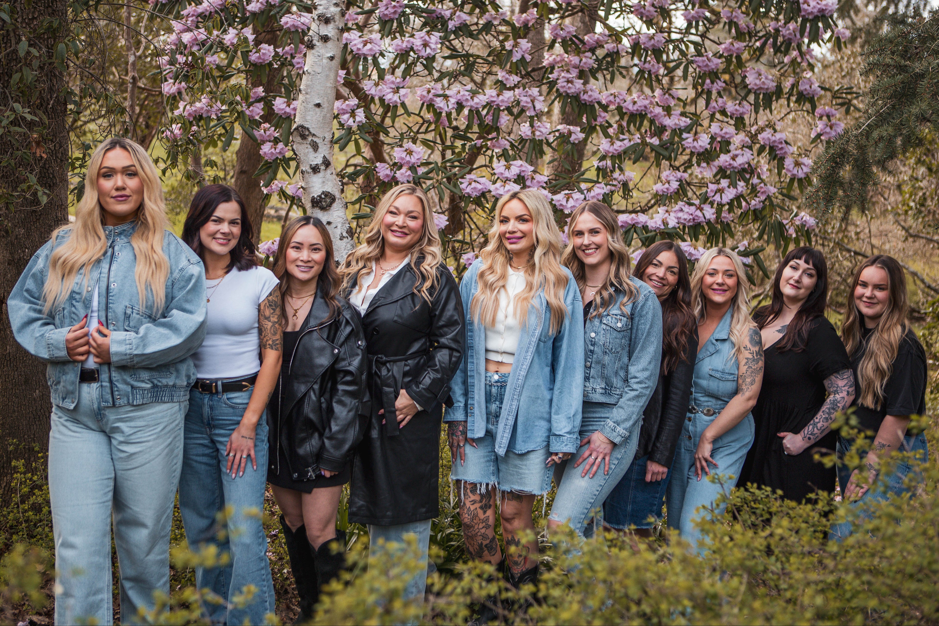 Group of women posing in a forest with cherry blossom trees in the background
